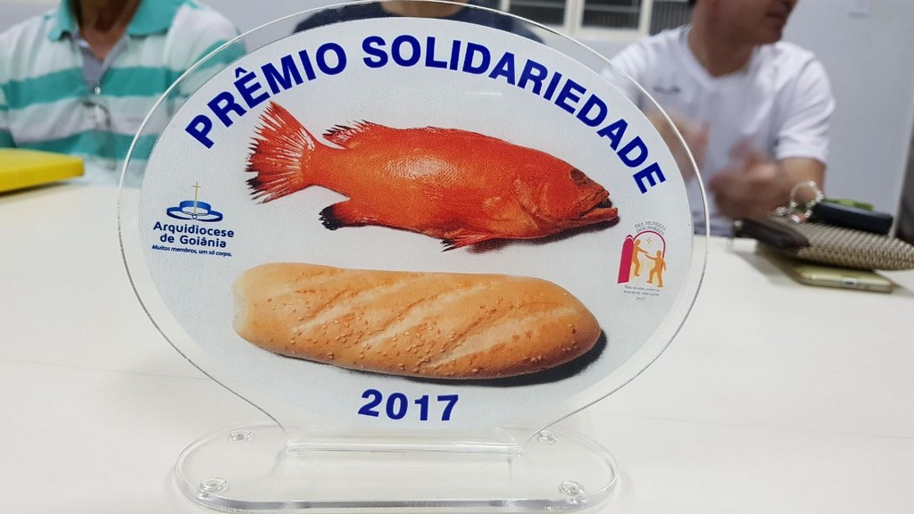 Integrantes da Pastoral da Moradia recebendo reconhecimento pelo trabalho social